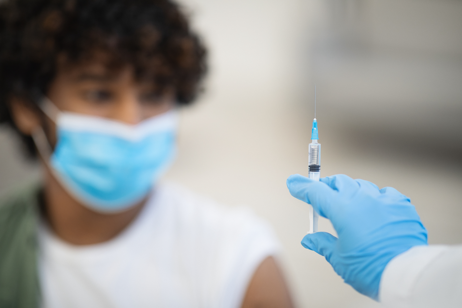Syringe with vaccine in unrecognizable doctor hand