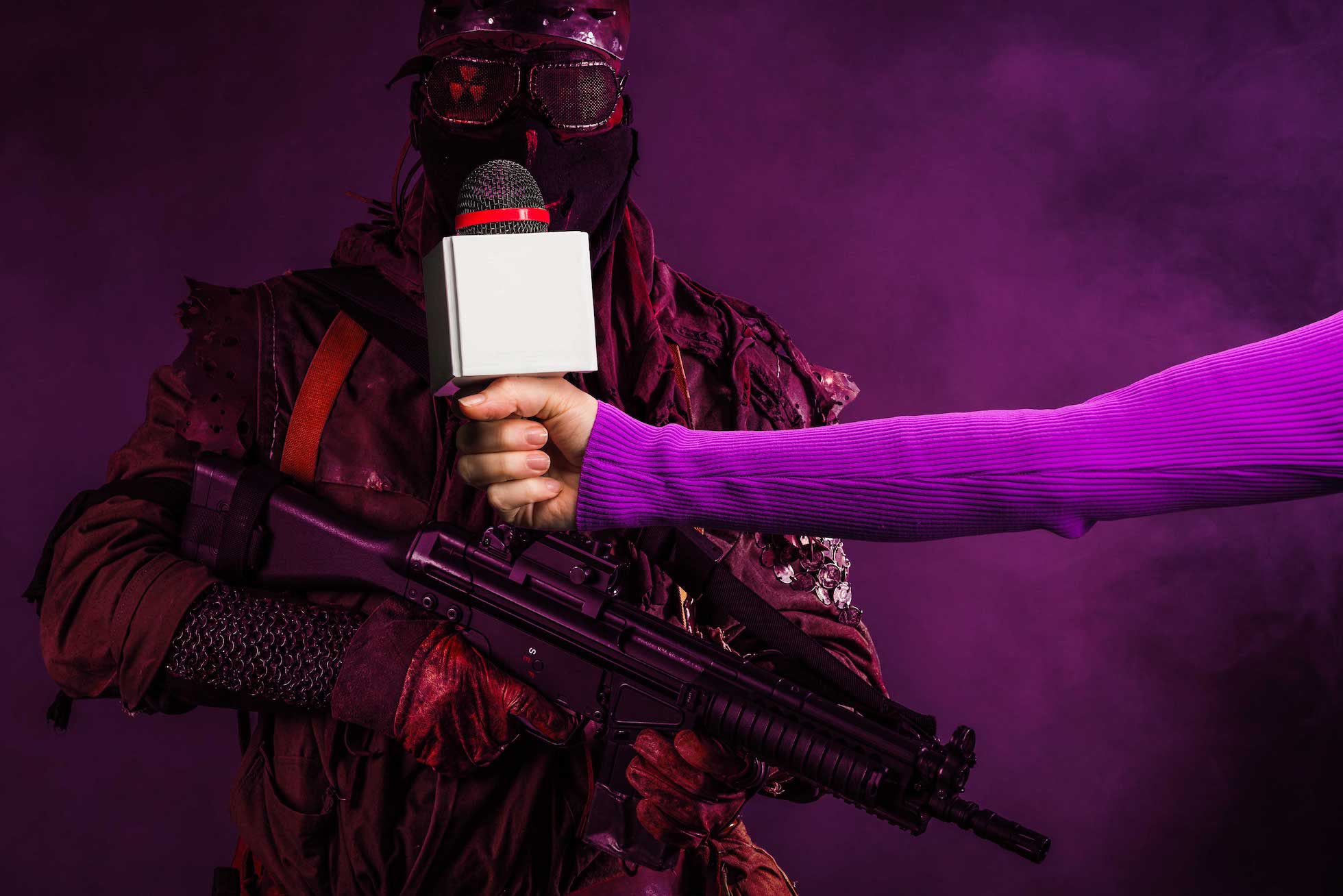 cropped view of reporter holding microphone on purple background