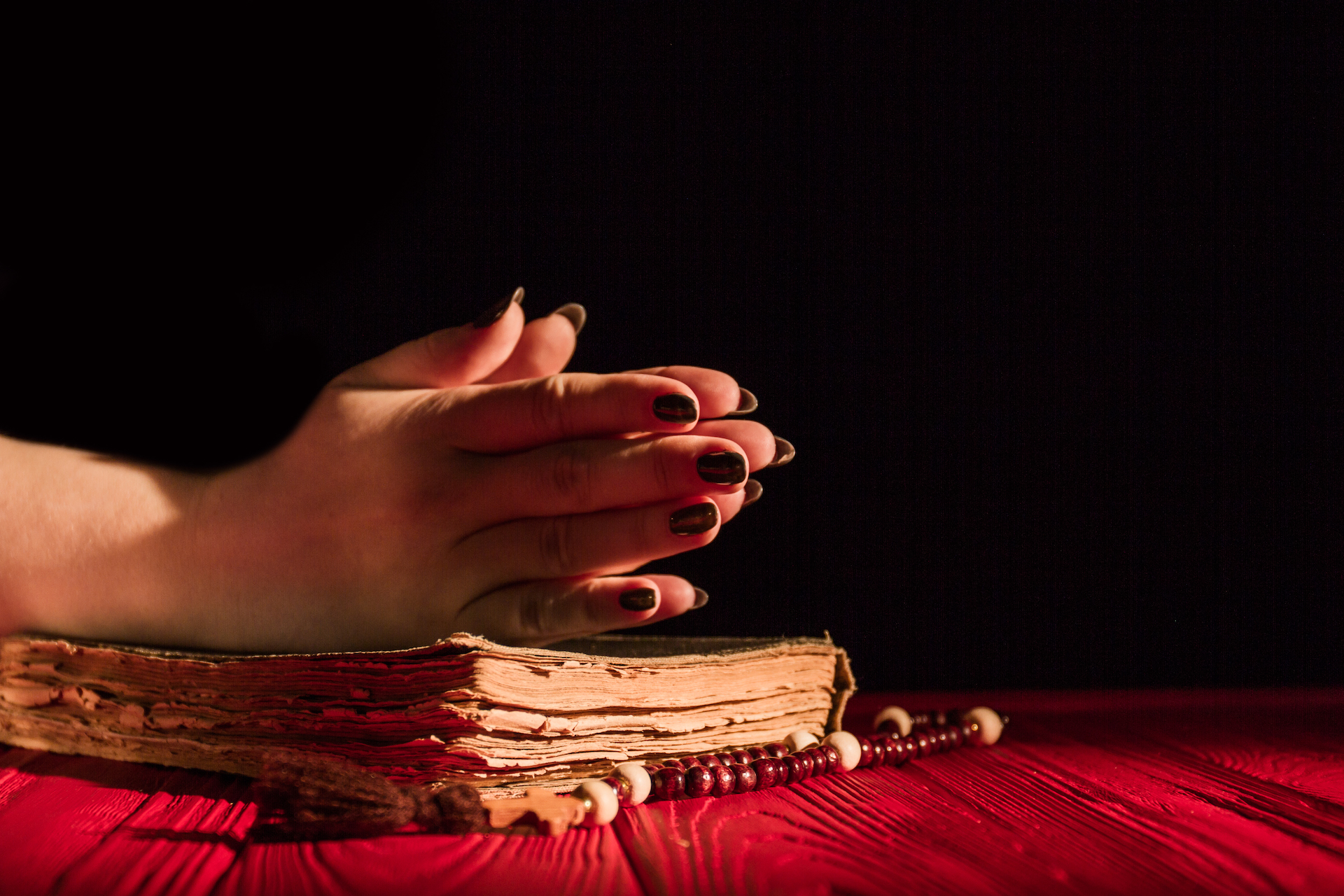 Praying hands on bible and rosary. donna che prega con il rosario