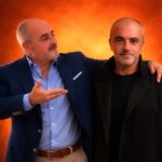 Uomo che presenta il proprio avatar digitale AI su sfondo arancione, esempio di utilizzo di un avatar AI per creator per creare contenuti in modo scalabile