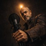 Uomo di 50 anni con microfono in studio registra musica con intelligenza artificiale per guadagnare online